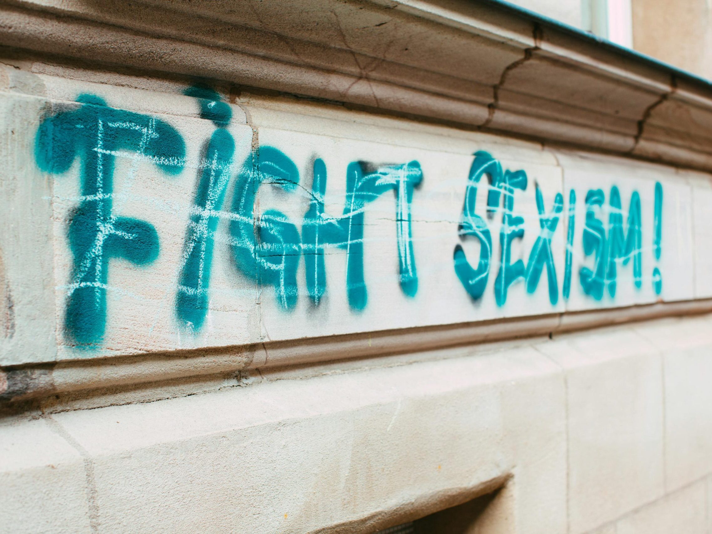 Street graffiti promoting equality with 'Fight Sexism!' message.